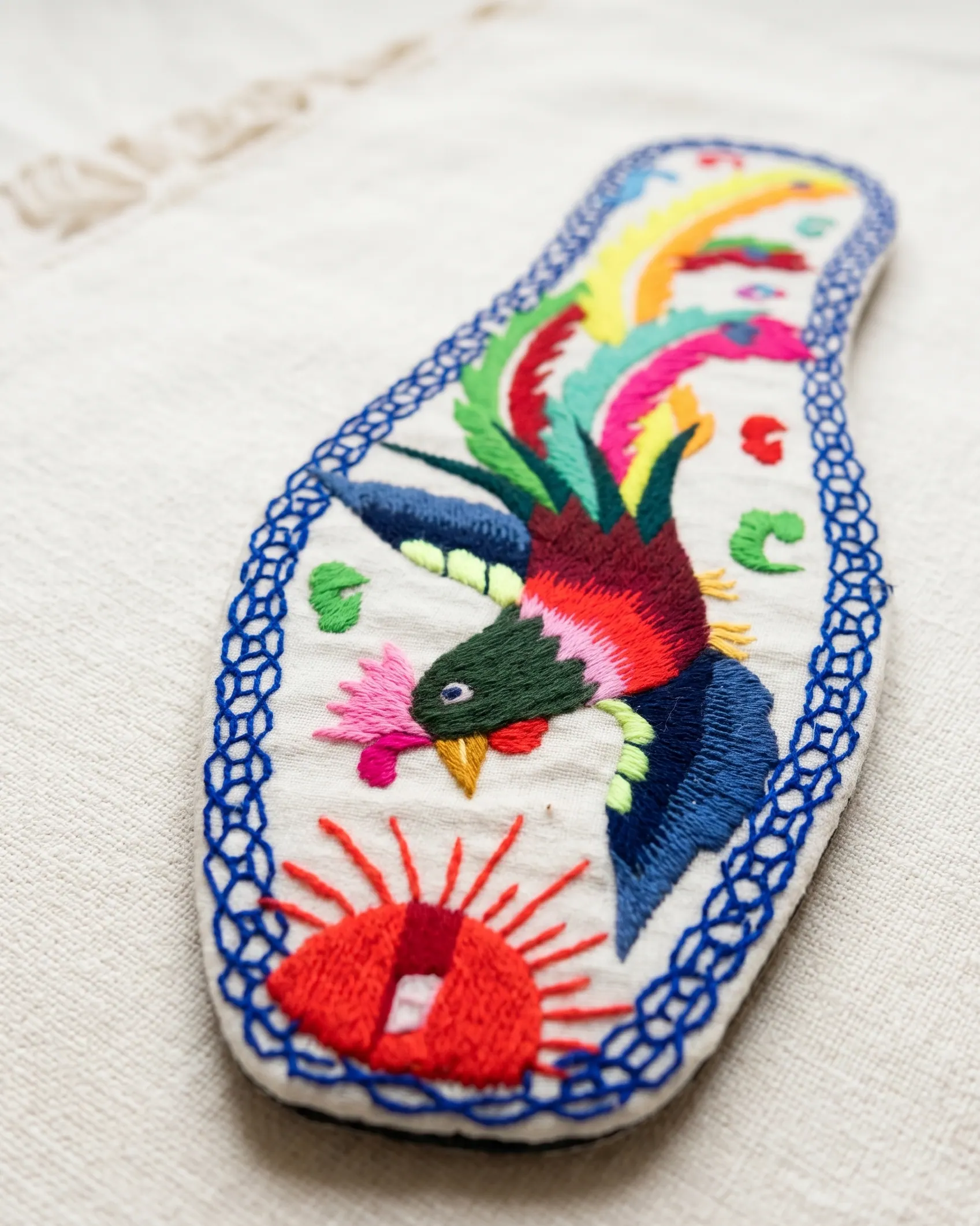 Phoenix motif embroidered in colour on an ivory insole — symbol of renewal and elegance