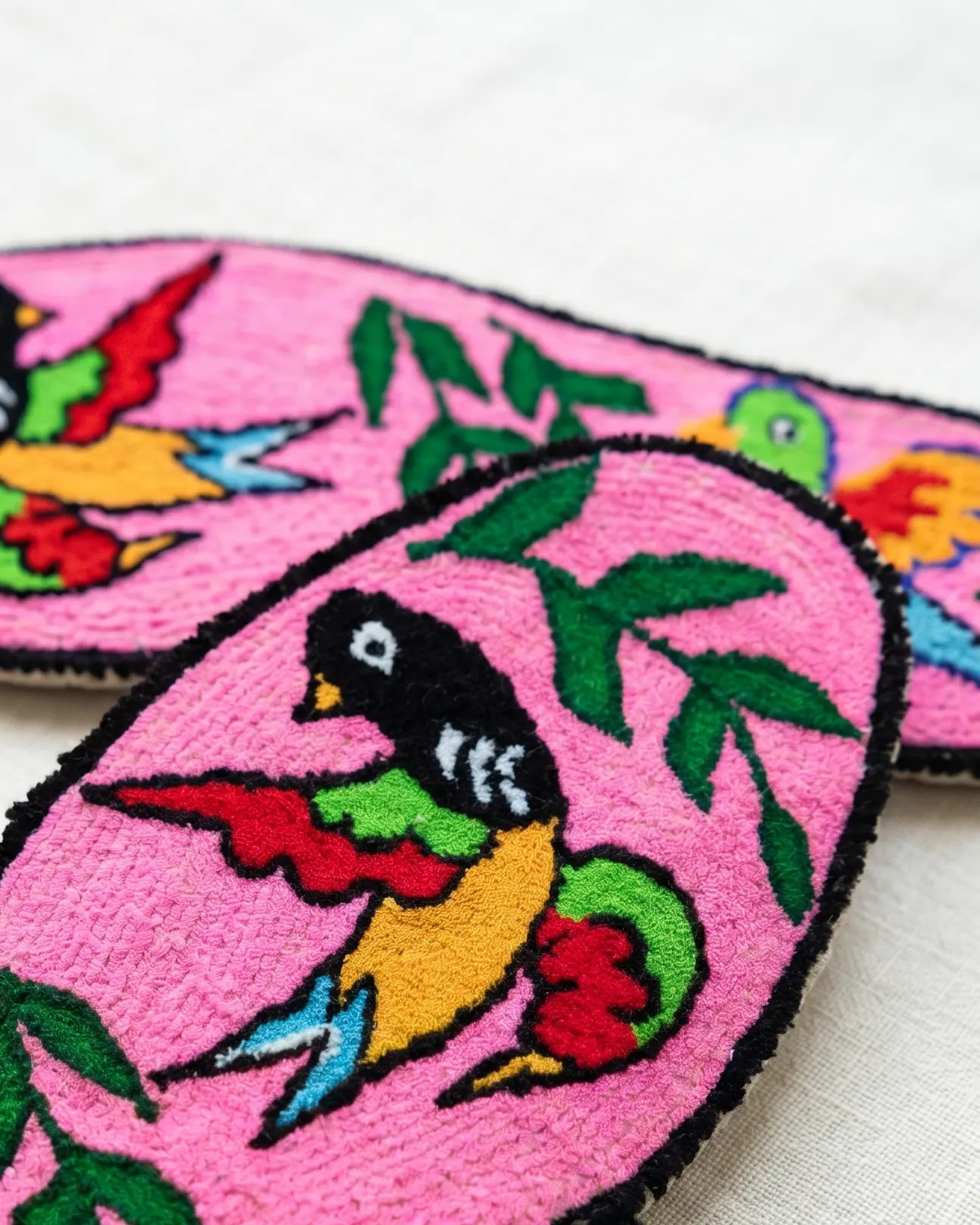 Swallow motif embroidered in rich colour on a pink insole — symbol of return and home